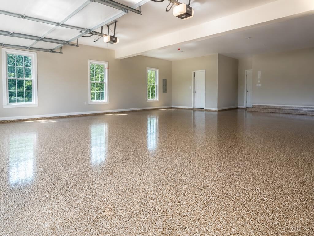 Three-car residential garage with a tan flake polyaspartic floor coating